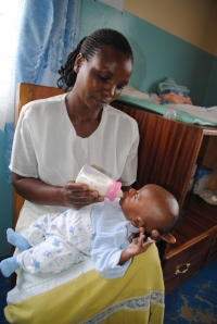Hausmutter Cynthia Cheboi füttert Baby Stefan.